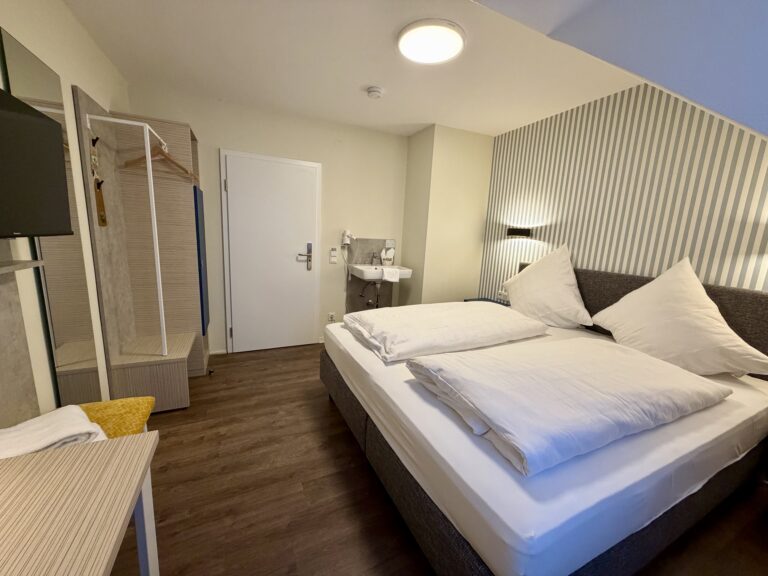 Double room with shared bathroom, double bed and washbasin